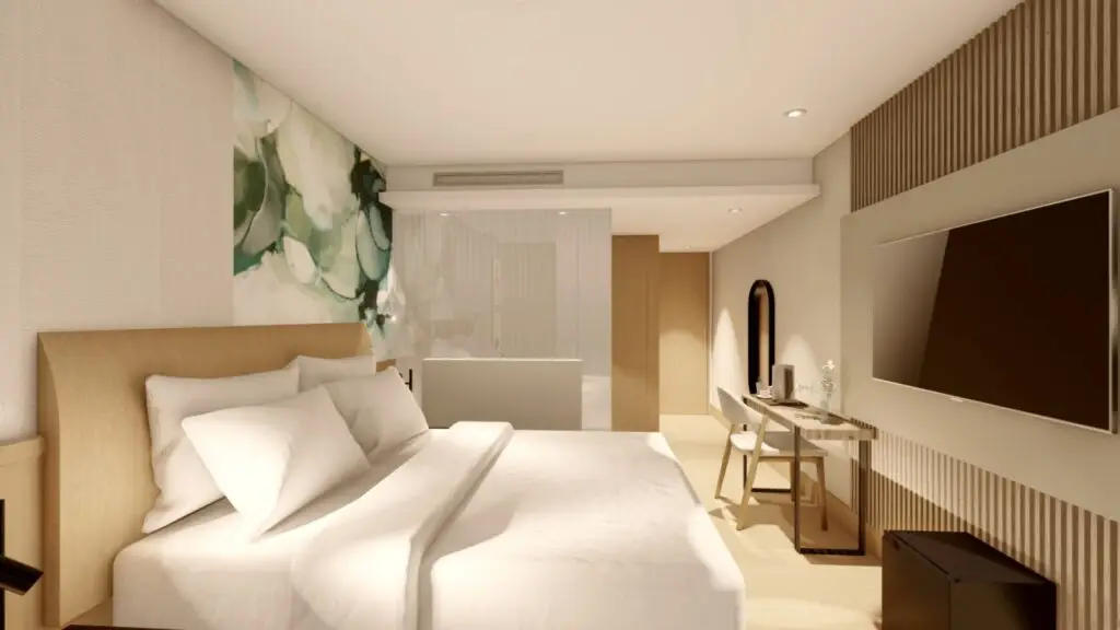 Modern hotel room with double bed, wall art, desk, and TV.