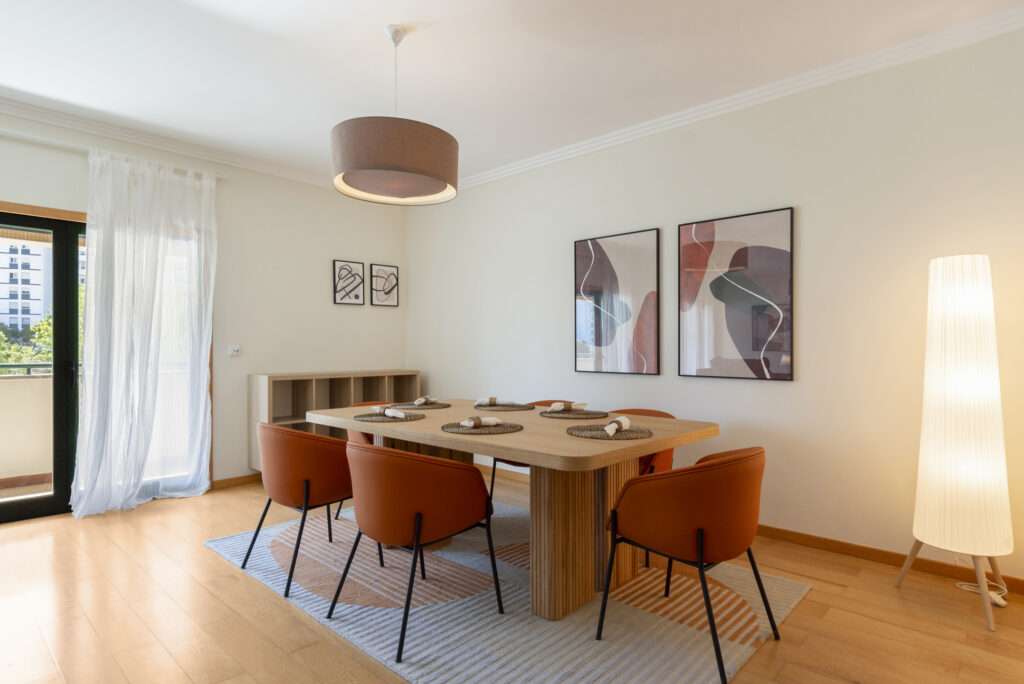 Contemporary dining room with wooden table, rust-colored chairs, abstract wall art, and soft lighting.